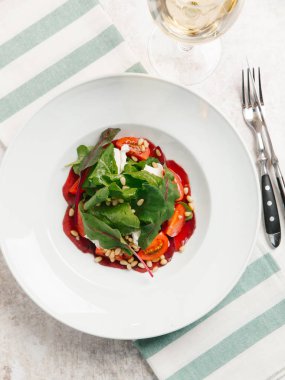  pancar salatası domates, yoğurt ve çam fıstığı üstten görünüm beyaz plaka üzerinde