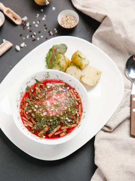 Borsch haşlanmış patates ve dereotu ile keten peçete beyaz tabakta ve baharat arka plan üzerinde