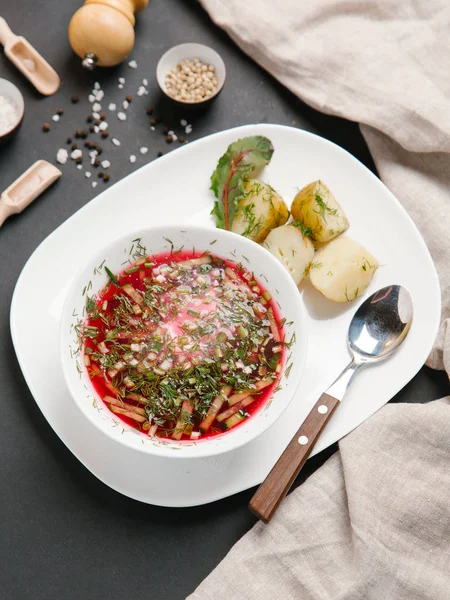 Borsch haşlanmış patates ve dereotu ile keten peçete beyaz tabakta ve baharat arka plan üzerinde