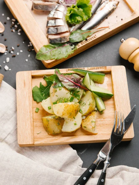 arka plan üzerine dilimlenmiş scomber ile ahşap tahta üzerinde yukarıdan kavrulmuş patates sebze ile servis 