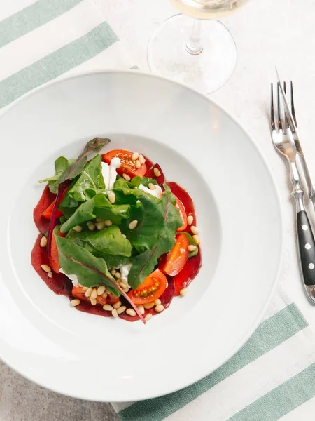 pancar salatası domates, yoğurt ve çam fıstığı üstten görünüm beyaz plaka üzerinde