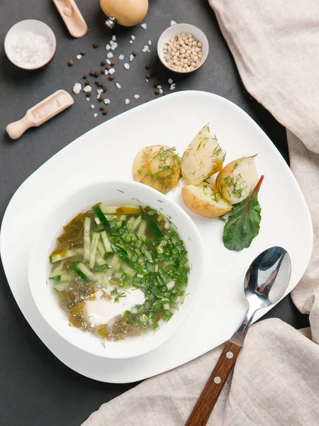 haşlanmış patates ve beyaz tabakta dereotu turşu çorbası