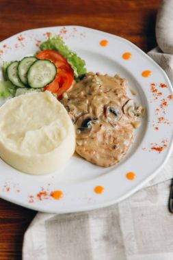 Beyaz tabakta sebze püresi patates ve mantar soslu