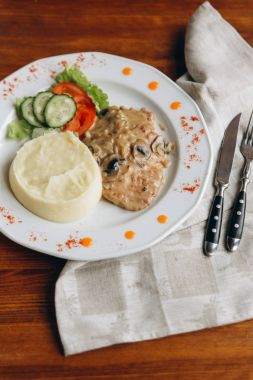 Beyaz tabakta sebze püresi patates ve mantar soslu