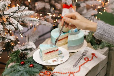 Jöle ve sufle ile el ve köknar, ışık ve arka plan üzerinde Noel dekorasyonu ile splited Noel kek