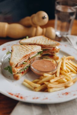 Sandviç, soslu ve patates kızartması ile geleneksel Amerikan yemek Görünümü Kapat.