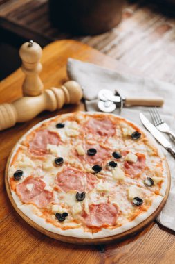 Keyifli pizzayla çatal keten peçete üzerinde Ahşap doğrama tahtası üzerinde 