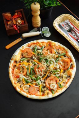 Ahşap yüzey üzerinde çatal bıçak takımı, karabiber öğütücüsü ve çiftlik lezzetli geleneksel İtalyan pizza Görünümü Kapat.