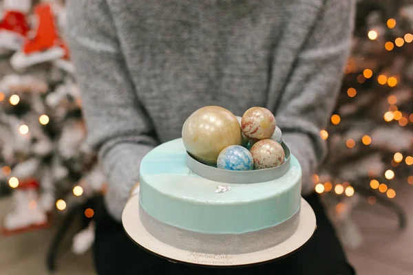 Midsection view of Christmas cake with chocolate balls on top in female hands
