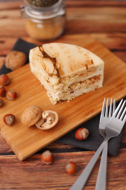 Doğrama kurulu, fındık, çatal ve peçete üzerinde doğum günü pastası ile kompozisyon