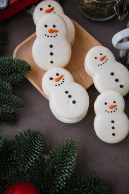 Macarons dalları gri kumaş üzerine bir kardan adam, ahşap plaka şeklinde ile kompozisyon