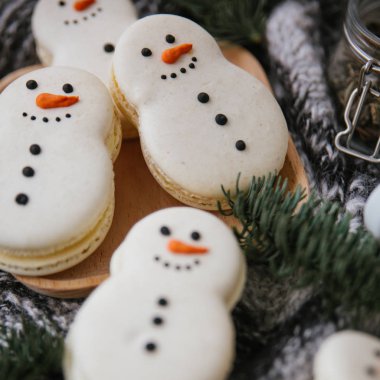 Bir kardan adam, ahşap plaka, dalları ve eşarp şeklinde macarons ile gıda kompozisyon closeup görünümü