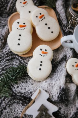 Bir kardan adam, ahşap plaka, dalları ve eşarp şeklinde macarons ile gıda kompozisyon closeup görünümü