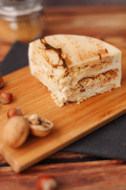 Doğrama kurulu, fındık, çatal ve peçete üzerinde doğum günü pastası ile kompozisyon