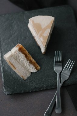 İki çatal ile gri plaka üzerinde iki dilim kek karanlık Gıda kompozisyonu