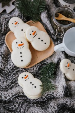 Bir kardan adam, ahşap plaka, dalları ve eşarp şeklinde macarons ile gıda kompozisyon closeup görünümü