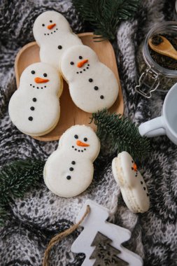 Bir kardan adam, ahşap plaka, dalları ve eşarp şeklinde macarons Gıda kompozisyonu