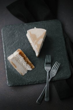 İki çatal ile gri plaka üzerinde iki dilim kek karanlık Gıda kompozisyonu
