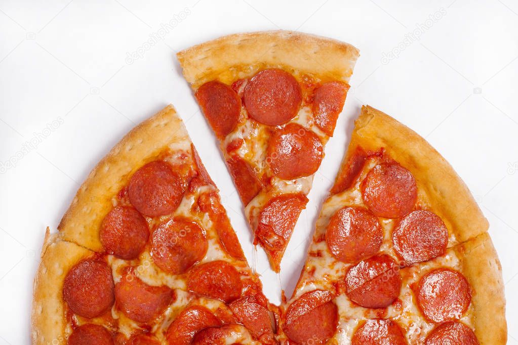Cutted in pieces tradition italian pizza with tomato sauce, cheese and pepperoni