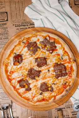 Sığır eti barışlar, mısır tohumları ve domates sosu üstüne lezzetli pizza