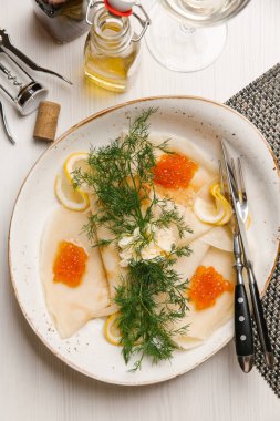 Krep kırmızı havyar, yağ, limon ve dereotu ile tabakta 