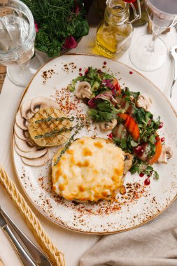 Biftek peynir ile kızarmış sarımsak ampul ve yeşil salata ile servis
