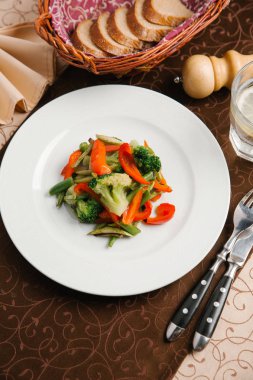 Brokoli, biber ve yeşil fasulye beyaz tabakta sebze salatası