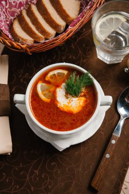 Çorba limon parçaları, dereotu ve ekşi krema ile servis 