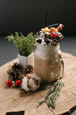 Tatlılar, payet, Noel topları, çam kozalakları ve biberiye dalları ile şenlikli kakao sawed tahtaya hizmet