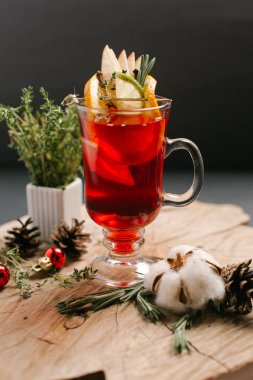 Kızılcık, limon, limon dilimleri ve Noel topları, çam kozalakları ve biberiye şube ile dekore edilmiş bal da dahil olmak üzere şenlikli tatlı içecek sawed tahtaya hizmet