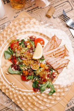 Bebek ile sıcak salata yaprakları, domates, mantar, limon dilimi, kızarmış soğan, sedir fındık ve jambon