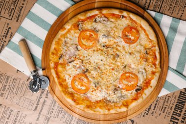 Ahşap tepsi peynirli pizza domates, jambon ve mantar ile hizmet