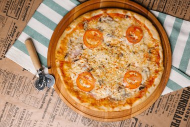 Ahşap tepsi peynirli pizza domates, jambon ve mantar ile hizmet