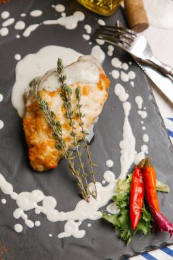 Biberiye, beyaz sos ve biber taş yönetim kurulu ile kavrulmuş tavuk göğsü servis