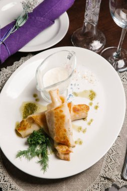 Pesto sos, ekşi krema ve dereotu beyaz tabakta servis swirled krep