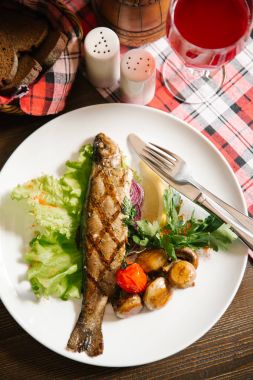 Izgara balık patates, domates, salata yaprağı, limon parça ve maydanoz ile