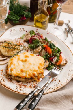 Biftek peynir ile kızarmış sarımsak ampul ve yeşil salata ile servis