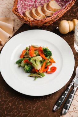 Brokoli, biber ve yeşil fasulye beyaz tabakta sebze salatası