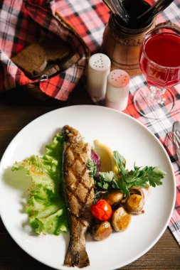 Izgara balık patates, domates, salata yaprağı, limon parça ve maydanoz ile Üstten Görünüm