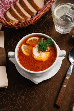 Çorba limon parçaları, dereotu ve ekşi krema ile servis 