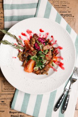 heyecan kızarmış Cantharellus cibarius yeşil yaprakları, domates ve tatlı ve ekşi sos