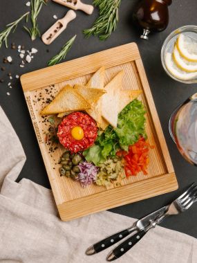   doğranmış kırmızı soğan, turşu ve dolmalık biber ile tost ile Forcemeat üst Bıldırcın yumurta ile servis