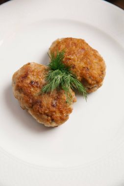 Dereotu şube ile beyaz tabakta ekmek kırıntıları ile iki tavuk pirzola