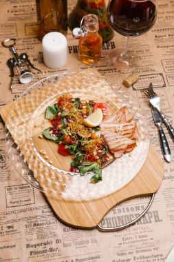 Bebek ile sıcak salata yaprakları, domates, mantar, limon dilimi, kızarmış soğan, sedir fındık ve jambon