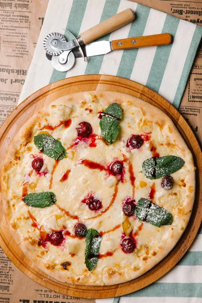 Sweet pizza with mozzarella, cherry and mint leaves