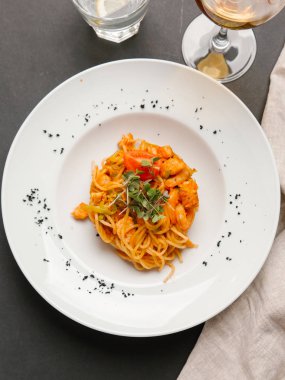  otlar ve beyaz tabakta domates parça ile spagetti karides ile servis