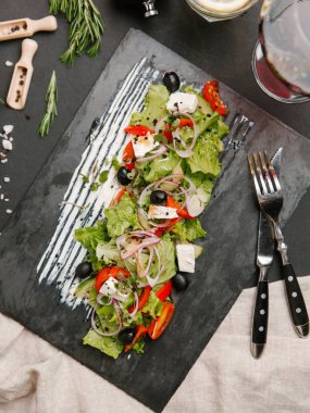 Yunan salatası karanlık taş tahtada beyaz sos ile