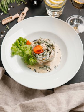 Yeşil fasulye ve domates parçaları ve marul ile servis kalamar salatası