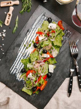 Yunan salatası karanlık taş tahtada beyaz sos ile