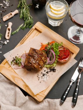 Kaburga eti sebze ve ahşap tepsi üzerinde domates sosu ile